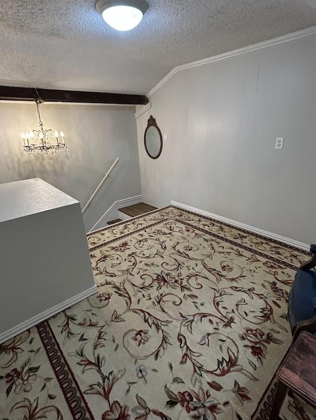 interior space featuring a chandelier, a textured ceiling, and ornamental molding