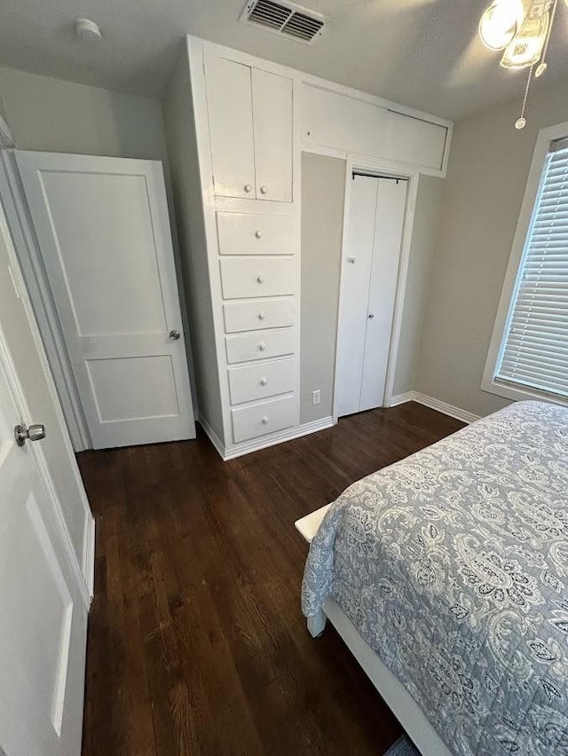 bedroom with visible vents, baseboards, and dark wood-style floors