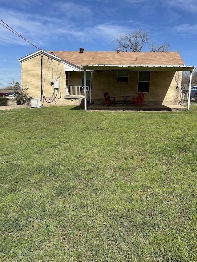 back of house featuring a patio area and a lawn