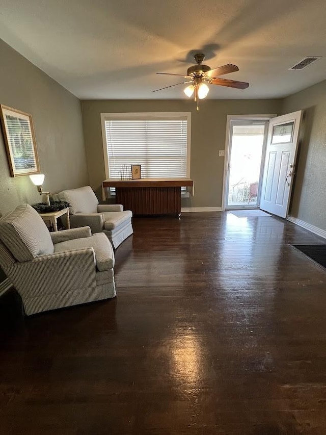 living room with ceiling fan and dark wood-type flooring