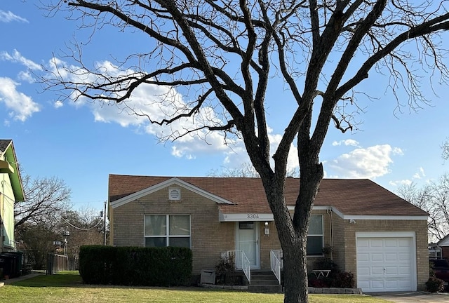 view of front of home with brick siding, a front yard, and a garage