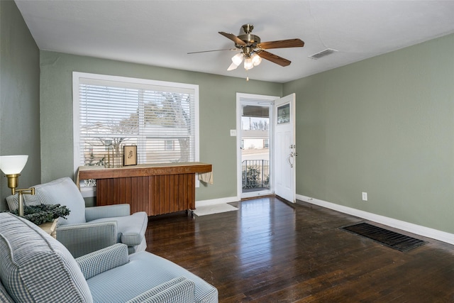 sitting room featuring dark hardwood / wood-style flooring, radiator heating unit, and ceiling fan