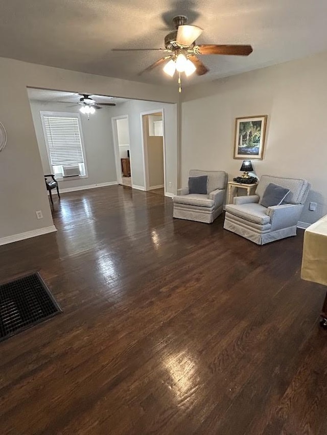 living room with baseboards, wood finished floors, visible vents, and ceiling fan