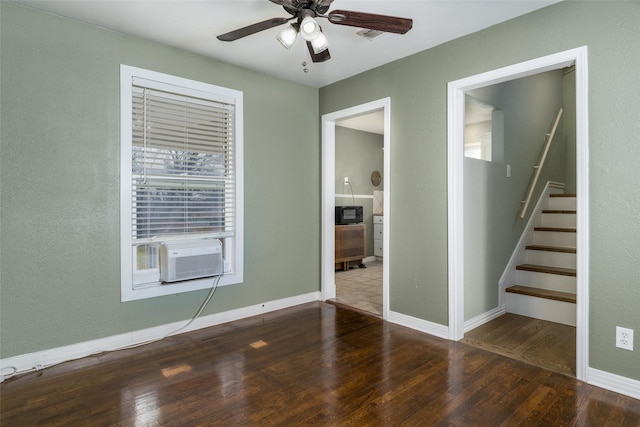 empty room featuring cooling unit, ceiling fan, and dark wood-type flooring