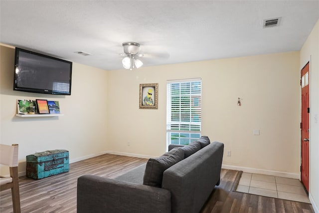 living room featuring a textured ceiling, hardwood / wood-style flooring, and ceiling fan