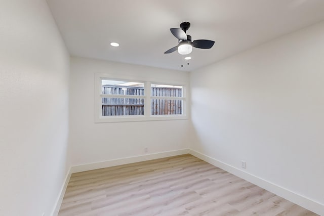 empty room with ceiling fan and light hardwood / wood-style flooring