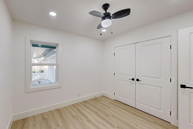 unfurnished bedroom with ceiling fan, light hardwood / wood-style floors, and a closet