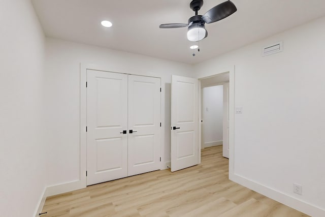 unfurnished bedroom with ceiling fan, a closet, and light hardwood / wood-style flooring