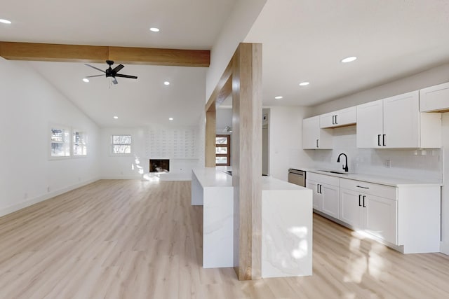 kitchen featuring ceiling fan, a large fireplace, sink, light hardwood / wood-style floors, and white cabinets