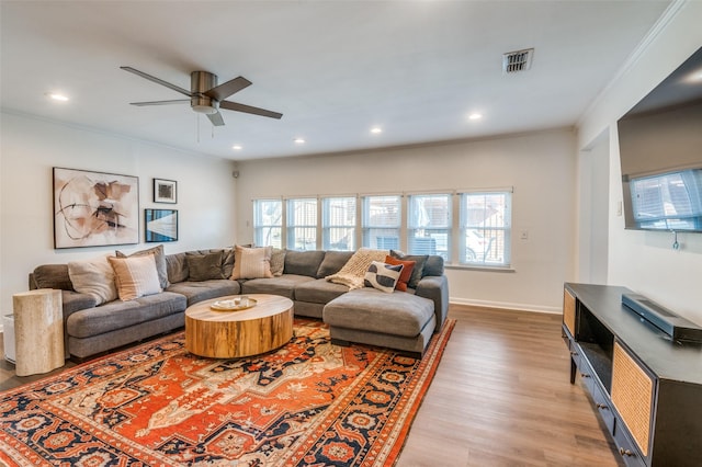 living room featuring ornamental molding, a wealth of natural light, light hardwood / wood-style floors, and ceiling fan