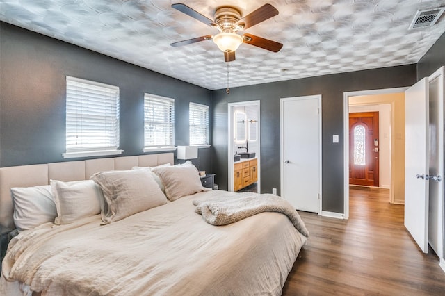 bedroom featuring hardwood / wood-style flooring, ceiling fan, and ensuite bath