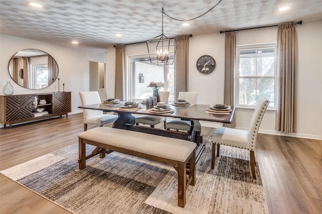 dining area featuring light wood-type flooring and an inviting chandelier