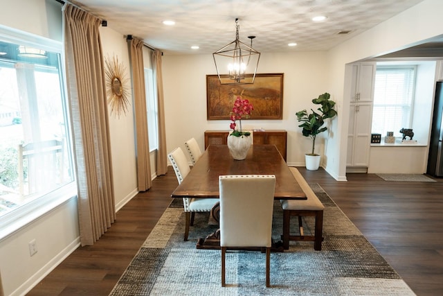 dining room with dark wood-type flooring and a chandelier