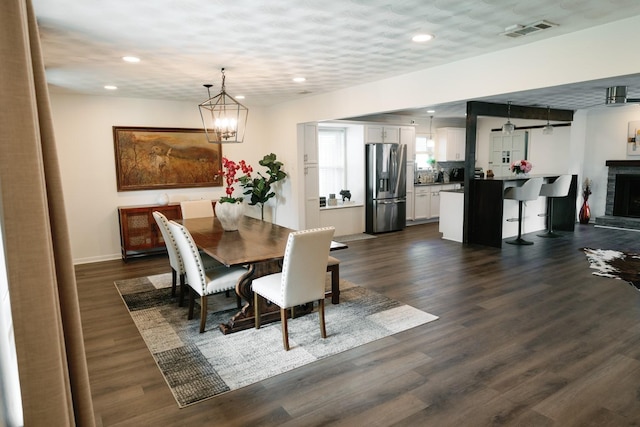 dining area featuring dark hardwood / wood-style floors and a chandelier