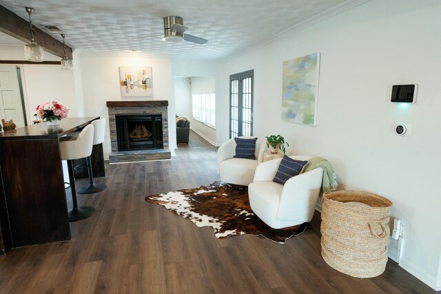 dining space featuring a stone fireplace, ceiling fan, crown molding, and hardwood / wood-style flooring