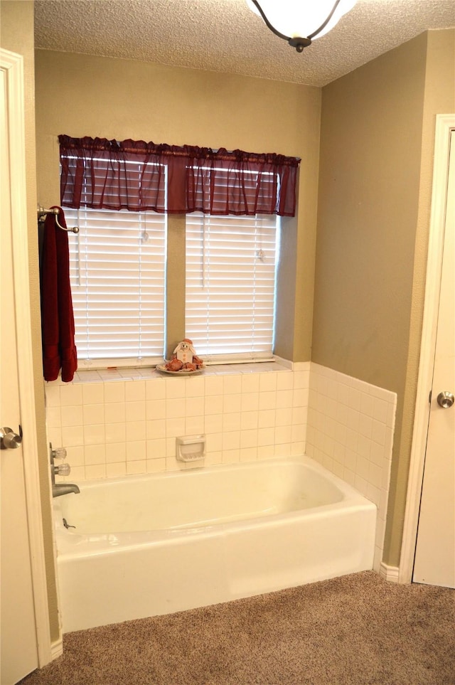 bathroom with a tub and a textured ceiling