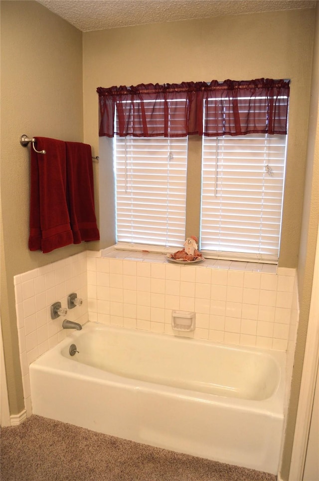 bathroom with a bathtub and a textured ceiling