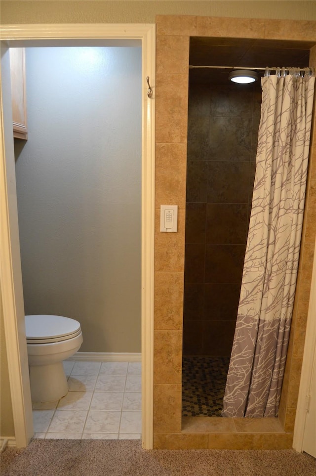 bathroom with tile patterned flooring, a shower with curtain, and toilet