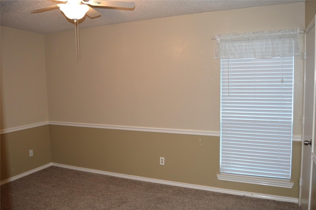 carpeted empty room featuring ceiling fan and a textured ceiling