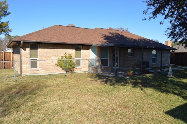 rear view of house featuring a yard