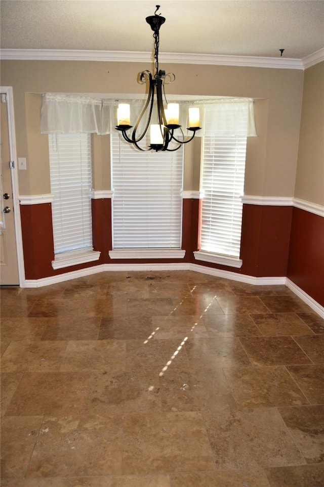 unfurnished dining area featuring ornamental molding and a notable chandelier