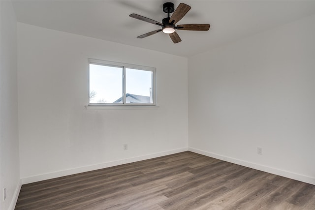 spare room featuring dark wood-type flooring and ceiling fan