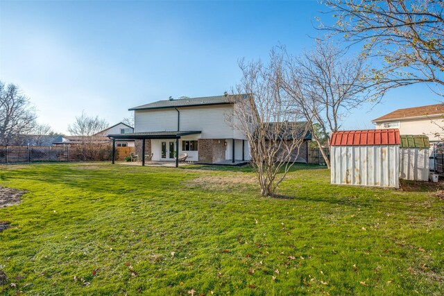 back of house featuring a yard and a shed