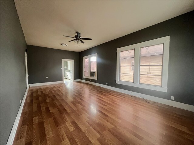 interior space with wood-type flooring, ceiling fan, and cooling unit