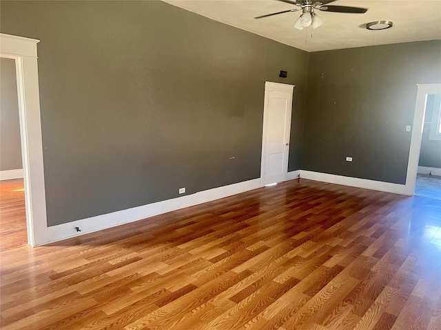 unfurnished room featuring a ceiling fan, lofted ceiling, wood finished floors, and baseboards