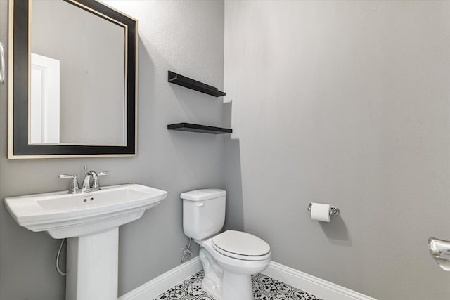 bathroom with tile patterned floors, a sink, toilet, and baseboards