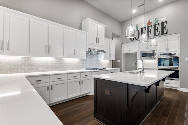 kitchen with pendant lighting, sink, white cabinets, and appliances with stainless steel finishes