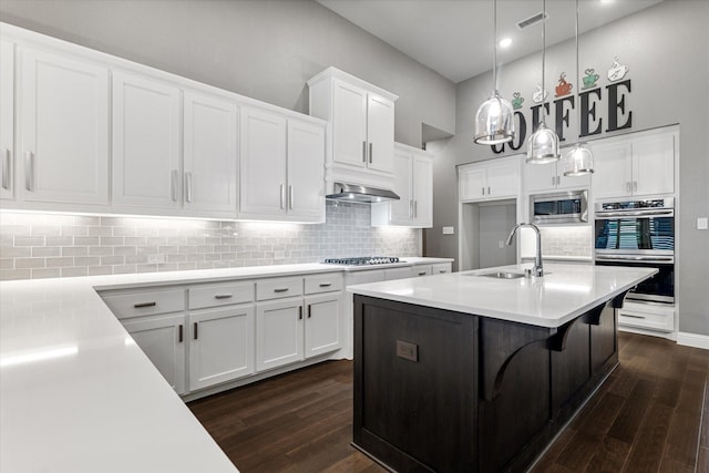 kitchen with dark wood-type flooring, a sink, appliances with stainless steel finishes, and visible vents