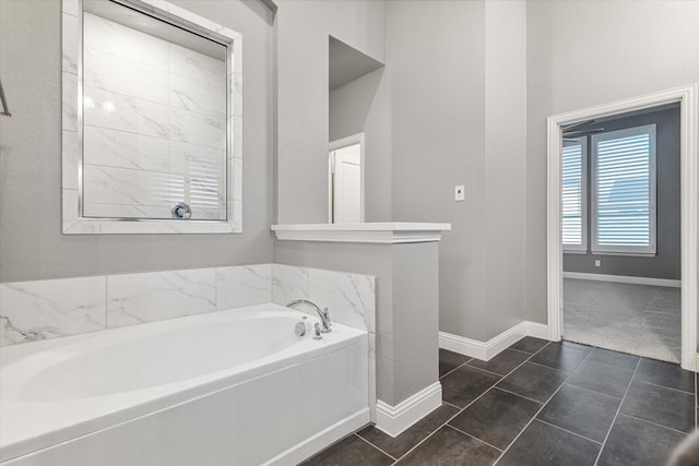 bathroom featuring a bath and baseboards