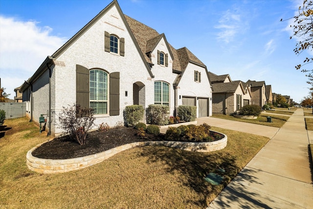 french provincial home with a garage and a front lawn