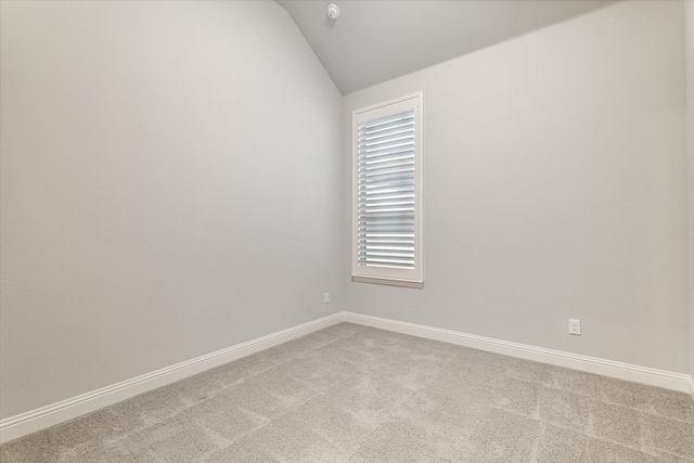 unfurnished room featuring light carpet and lofted ceiling