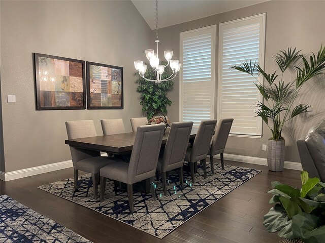 dining room featuring an inviting chandelier, wood finished floors, lofted ceiling, and baseboards