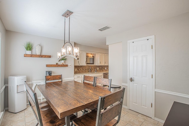 dining space with an inviting chandelier, sink, and light tile patterned floors