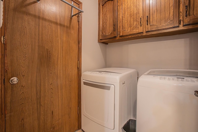 laundry area featuring independent washer and dryer and cabinets