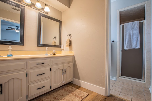 bathroom featuring hardwood / wood-style flooring, ceiling fan, vanity, and an enclosed shower