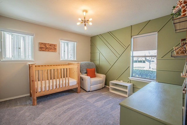 carpeted bedroom featuring a nursery area, multiple windows, and a notable chandelier