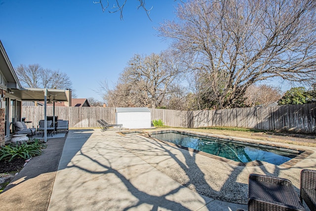 view of pool with a shed and a patio area