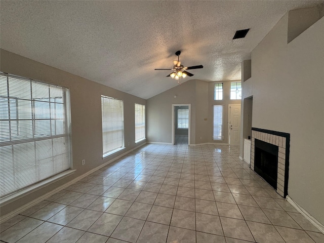 unfurnished living room with ceiling fan, lofted ceiling, light tile patterned floors, and a fireplace