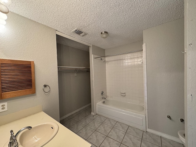 full bathroom with vanity, tiled shower / bath combo, tile patterned flooring, and a textured ceiling