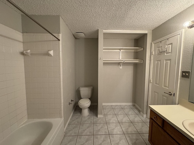 full bathroom with tile patterned floors, toilet, tiled shower / bath, a textured ceiling, and vanity