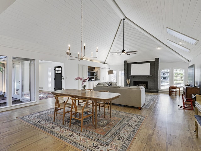 dining area featuring hardwood / wood-style floors, high vaulted ceiling, a brick fireplace, and wooden ceiling