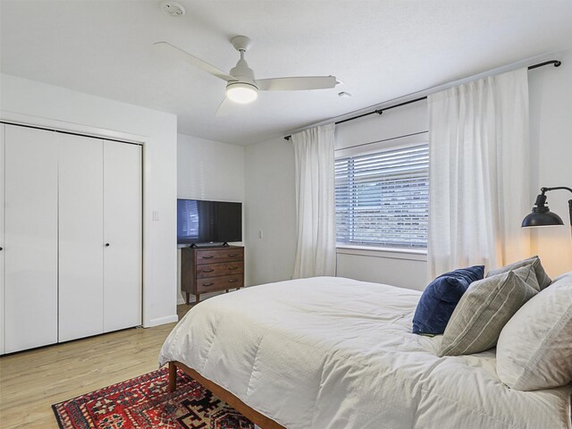 bedroom featuring ceiling fan, light wood-type flooring, and a closet