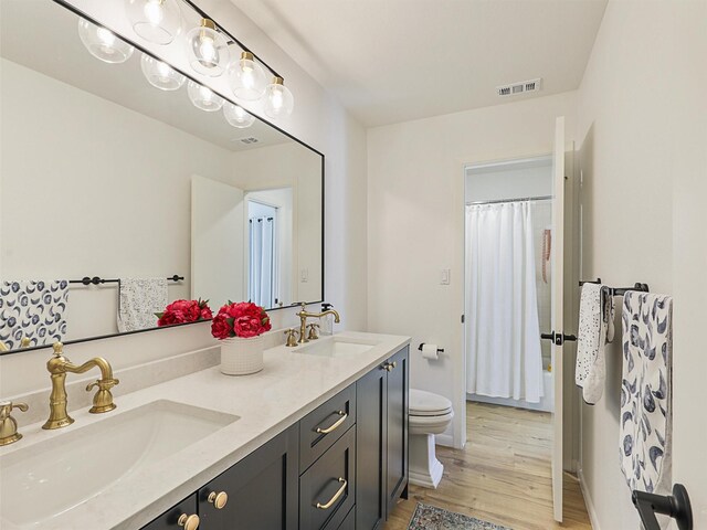 bathroom with hardwood / wood-style floors, vanity, and toilet