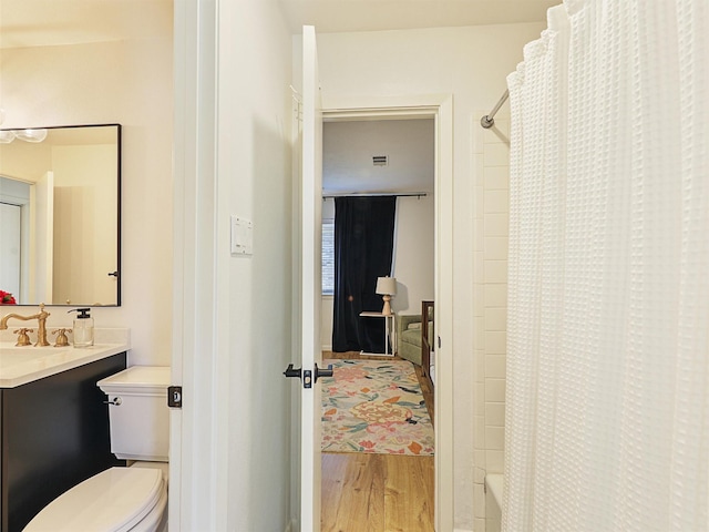 full bathroom with shower / bath combination with curtain, vanity, hardwood / wood-style flooring, and toilet