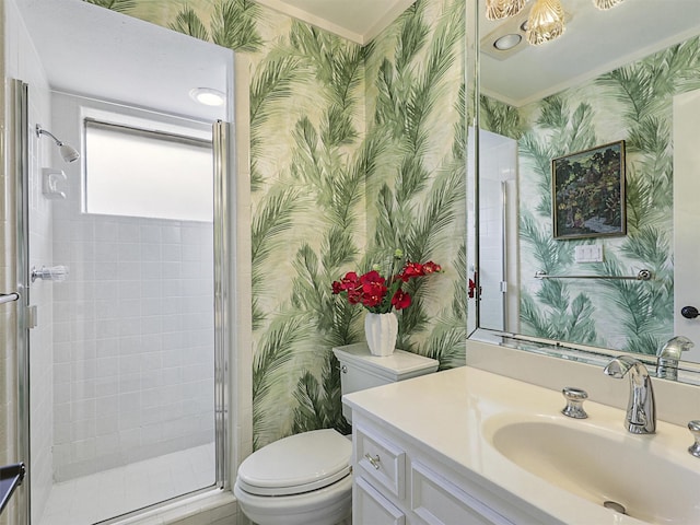 bathroom with vanity, toilet, a shower with door, and ornamental molding