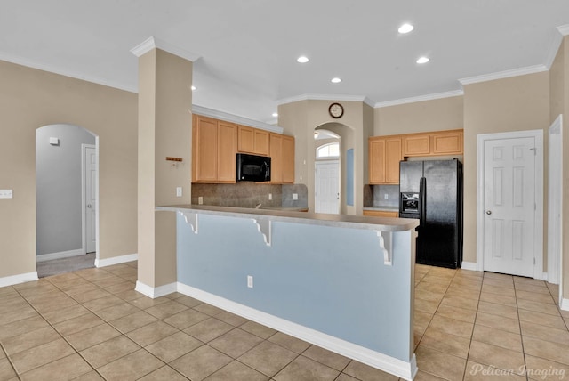 kitchen with black appliances, a breakfast bar area, light tile patterned floors, kitchen peninsula, and light brown cabinets